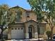 Two story home featuring a two car garage, covered front porch, and a tile roof at 4256 Perfect Drift St, Las Vegas, NV 89129