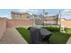 Artificial grass in backyard with a trampoline, barbecue grill, and gravel landscaping at 4347 Outlook Vista Ave, North Las Vegas, NV 89084
