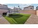 Backyard features a trampoline, artificial grass, and gravel landscaping at 4347 Outlook Vista Ave, North Las Vegas, NV 89084