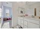 Bright bathroom with double sinks, white cabinets, and a view into the adjacent bedroom at 4347 Outlook Vista Ave, North Las Vegas, NV 89084