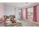 Well-lit bedroom featuring pink curtains, a plush bed, and ample space for toys at 4347 Outlook Vista Ave, North Las Vegas, NV 89084