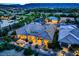 Twilight aerial view of a desert home with a landscaped backyard, lighting, and a covered patio at 4564 Bersaglio St, Las Vegas, NV 89135