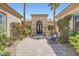 Inviting front entrance features custom iron doors, lush landscaping, and a cozy sitting area at 4564 Bersaglio St, Las Vegas, NV 89135