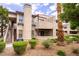Multi-level condo building featuring tan stucco, stairs, and green landscaping at 5060 Jeffreys St # 201, Las Vegas, NV 89119