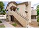 Multi-level condo building with tan stucco, stairs, and beautiful landscaping at 5060 Jeffreys St # 201, Las Vegas, NV 89119