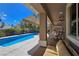 Wide angle view of covered back patio with ceiling fan and comfortable seating overlooking the refreshing pool at 5416 Alabaster Ct, Las Vegas, NV 89149