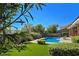 Lush backyard featuring a sparkling pool, mature trees, and pristine artificial turf at 5416 Alabaster Ct, Las Vegas, NV 89149