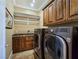 Laundry room with granite countertops, washer, dryer, shelves, and tile floor at 5416 Alabaster Ct, Las Vegas, NV 89149