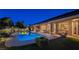 Nighttime view of the backyard with a sparkling pool, covered patio, and illuminated landscaping at 5416 Alabaster Ct, Las Vegas, NV 89149