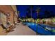 Backyard pool at twilight featuring mature trees, lounge chairs and manicured landscaping at 5416 Alabaster Ct, Las Vegas, NV 89149