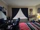 Spacious bedroom featuring a computer desk and black chair, accented with black curtains and posters at 5419 Centurion Ct # 102, Las Vegas, NV 89122