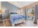 Comfortable bedroom with a queen bed, soft blue walls, and sliding glass doors to the outside patio area at 5532 Sentinel Bridge St, Las Vegas, NV 89130