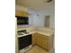 Galley kitchen featuring light wood cabinets, light countertops, and black appliances at 600 Sarajane Ln, Las Vegas, NV 89107
