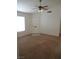 Cozy living room features neutral carpeting, a ceiling fan, and a front door at 600 Sarajane Ln, Las Vegas, NV 89107