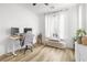 Cozy bedroom featuring hardwood floors, white walls, comfortable desk, and bright natural light at 6142 W Levi Ave, Las Vegas, NV 89141