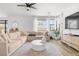 Spacious living room boasts hardwood floors, large windows, and a comfortable sectional at 6142 W Levi Ave, Las Vegas, NV 89141