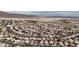 High angle showcases a neighborhood with uniform houses, curvilinear streets, and a mountainous backdrop at 6407 Wild Strawberry Ln, Las Vegas, NV 89142