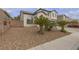 Lovely two-story home featuring a rock lawn, stucco walls, and an arched window at 6407 Wild Strawberry Ln, Las Vegas, NV 89142