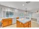 Kitchen featuring island with tile countertop, white appliances, and wood cabinets at 6407 Wild Strawberry Ln, Las Vegas, NV 89142