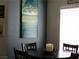 This dining area features a decorative painting, a dark table, and window with natural light at 6480 Annie Oakley Dr # 111, Las Vegas, NV 89120