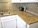 Close up of granite countertop with a stainless steel sink and white appliances in a stylish kitchen at 6480 Annie Oakley Dr # 111, Las Vegas, NV 89120
