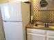 Kitchen featuring white appliances and an eye-catching golden tile backsplash at 6480 Annie Oakley Dr # 111, Las Vegas, NV 89120