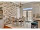 Elegant dining area with backyard views, a stylish light fixture, and a stone accent wall at 708 Canterbury Cross Pl, Las Vegas, NV 89144