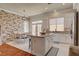 Spacious kitchen featuring an island, stone accent wall, stainless appliances, and a dining area with access to the pool at 708 Canterbury Cross Pl, Las Vegas, NV 89144