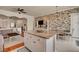 Open kitchen with an island, granite countertops, and a dining area with stone accent wall at 708 Canterbury Cross Pl, Las Vegas, NV 89144