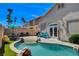 Outdoor pool and patio space surrounded by Palm trees and blue skies at 708 Canterbury Cross Pl, Las Vegas, NV 89144