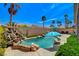 Backyard oasis with a sparkling pool, rock features, lush greenery, and ample space for outdoor relaxation at 708 Canterbury Cross Pl, Las Vegas, NV 89144