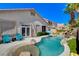 Inviting backyard pool area with a waterfall feature, lush landscaping, and outdoor seating at 708 Canterbury Cross Pl, Las Vegas, NV 89144
