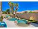 Outdoor pool and garden with Palm Trees under bright blue sky at 708 Canterbury Cross Pl, Las Vegas, NV 89144