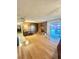 Open living room with brick fireplace, wood paneled walls and hardwood floors at 7200 Alta Dr, Las Vegas, NV 89145
