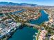 Stunning aerial view of the lake community featuring beautiful waterfront properties and mountain views at 7632 Spruce Run Ct, Las Vegas, NV 89128