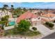 Expansive community view featuring a two-story home with a two-car garage, lush landscaping, and a terracotta roof at 7632 Spruce Run Ct, Las Vegas, NV 89128