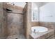 This bathroom showcases a tiled walk-in shower and separate soaking tub with window view at 7632 Spruce Run Ct, Las Vegas, NV 89128