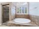 A luxurious bathroom featuring a soaking tub, shower and a window with plantation shutters at 7632 Spruce Run Ct, Las Vegas, NV 89128