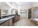 This is a spacious bathroom with dual sinks, granite counters, and a separate tub and shower at 7632 Spruce Run Ct, Las Vegas, NV 89128