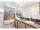 Bathroom with double sink vanity, granite counters, tile floors, and tiled shower and bath at 7632 Spruce Run Ct, Las Vegas, NV 89128