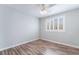Well lit bedroom features wood floors, white walls, white trim, and shuttered windows at 7632 Spruce Run Ct, Las Vegas, NV 89128