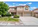 Two-story home with a red tile roof and three car garage with manicured front yard and walkway at 7632 Spruce Run Ct, Las Vegas, NV 89128