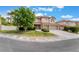 View of a two-story home with a red tile roof, three car garage, and landscaped front yard at 7632 Spruce Run Ct, Las Vegas, NV 89128