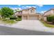 Two-story home with a red tile roof, three car garage and well landscaped front yard on a sunny day at 7632 Spruce Run Ct, Las Vegas, NV 89128