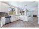 Bright kitchen features white cabinets, granite counters, stainless appliances, large window, and open floorplan at 7632 Spruce Run Ct, Las Vegas, NV 89128