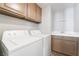 Laundry room with washer, dryer, storage cabinets, sink, and tile floors at 7632 Spruce Run Ct, Las Vegas, NV 89128
