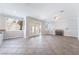Spacious living room featuring double doors to backyard, a fireplace, and neutral tile floors at 7632 Spruce Run Ct, Las Vegas, NV 89128