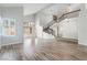 Bright, open living area with soaring ceilings, laminate floors, staircase, and large windows at 7632 Spruce Run Ct, Las Vegas, NV 89128