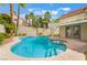 Backyard view of swimming pool with spa, palm trees, pergola covered patio, and stucco house at 7632 Spruce Run Ct, Las Vegas, NV 89128