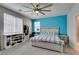 Comfortable main bedroom featuring a large window, blue accent wall, and ceiling fan at 7821 Mazarine St, North Las Vegas, NV 89084